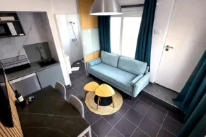 Vista superior del salón con sofá moderno, mesa de comedor y cocina americana