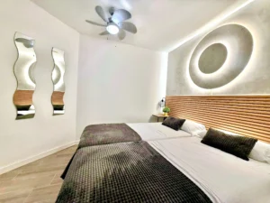 Habitación con ventilador de techo, espejos decorativos y luces ambiente