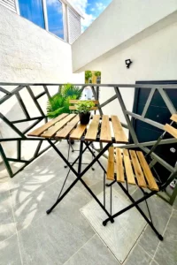Terraza privada con mesa y sillas de madera para disfrutar al aire libre