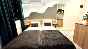 Vista desde los pies de la cama hacia la pared decorada y luces de ambiente