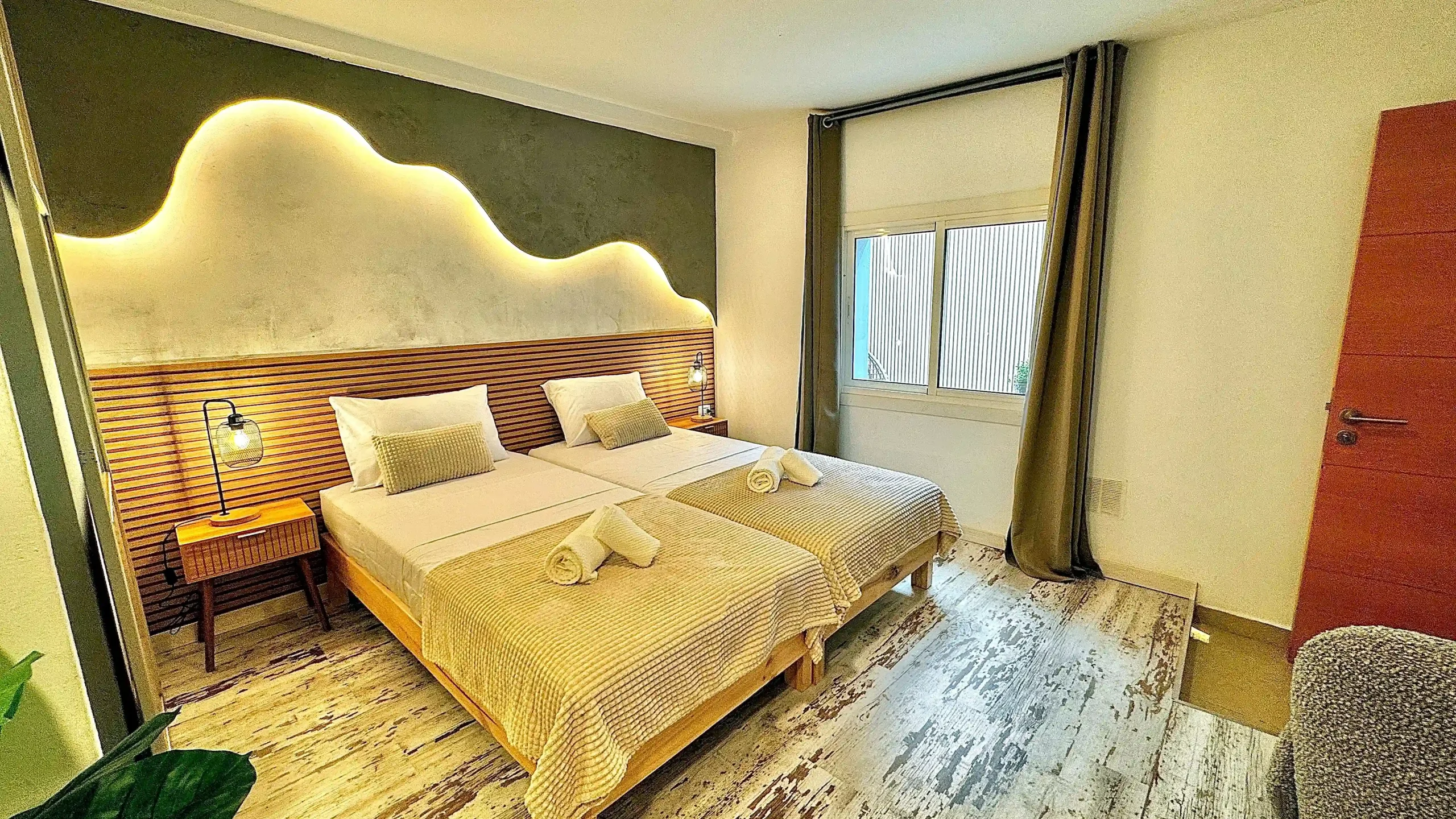 Habitación interior tranquila con dos camas individuales e iluminación LED ambiental