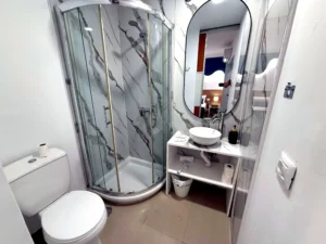 Cuarto de baño privado con cabina de ducha y lavabo moderno