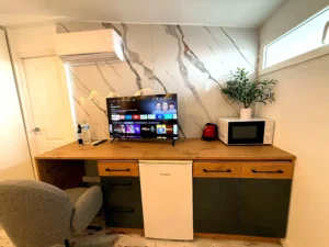 Zona de escritorio completa con televisión, minibar y microondas