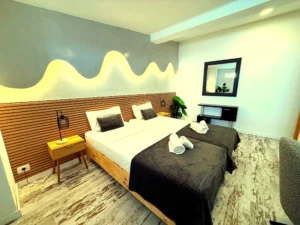 Vista general del dormitorio amplio con suelo de madera y zona de trabajo